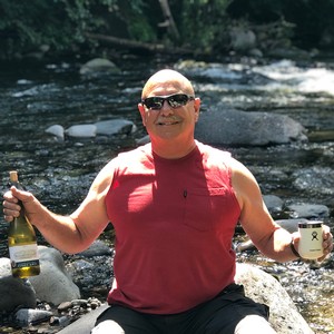 CFO Rich holding Pnot Gris next to the Breitenbush River while camping
