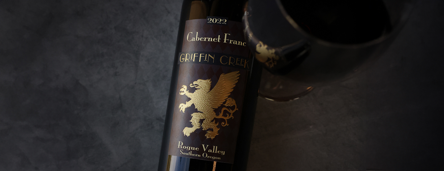 A hand pulling a bottle of Willamette Valley Vineyards Wines from a wine rack.