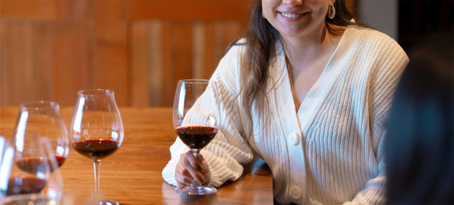 A woman drinking a glass of Pinot Noir