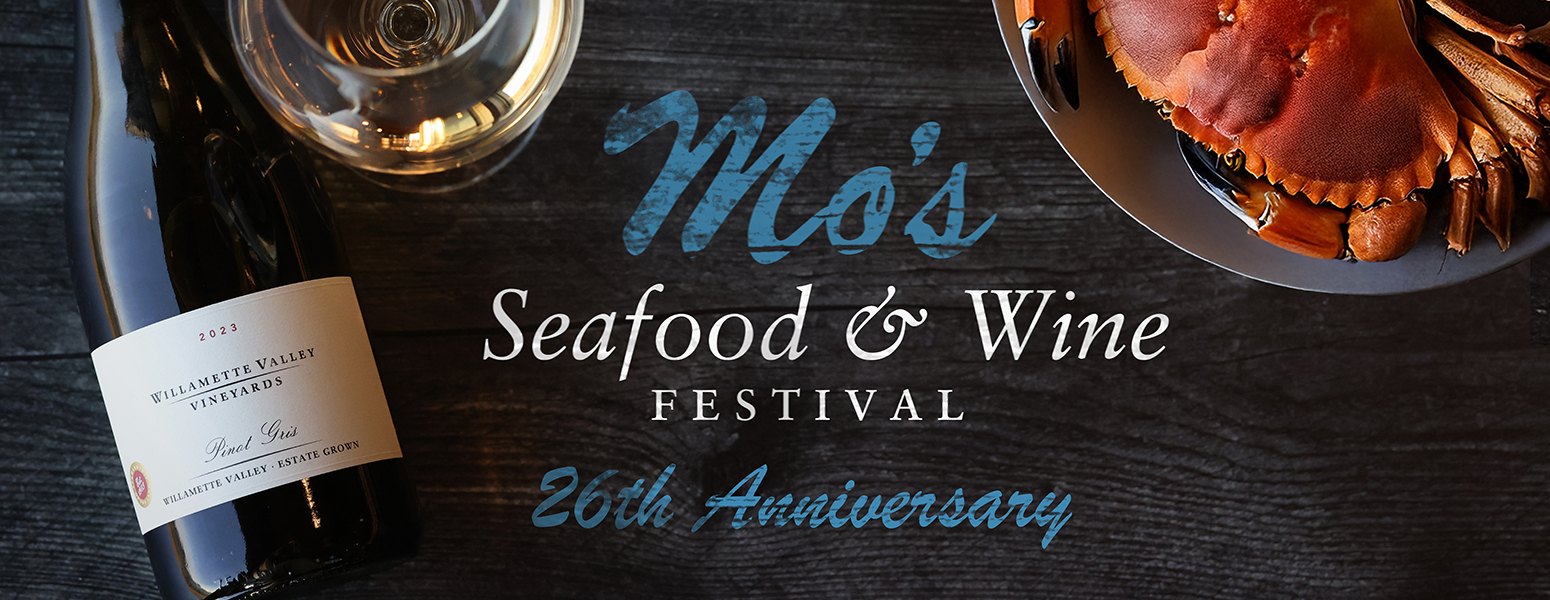 A hand pulling a bottle of Willamette Valley Vineyards Wines from a wine rack.