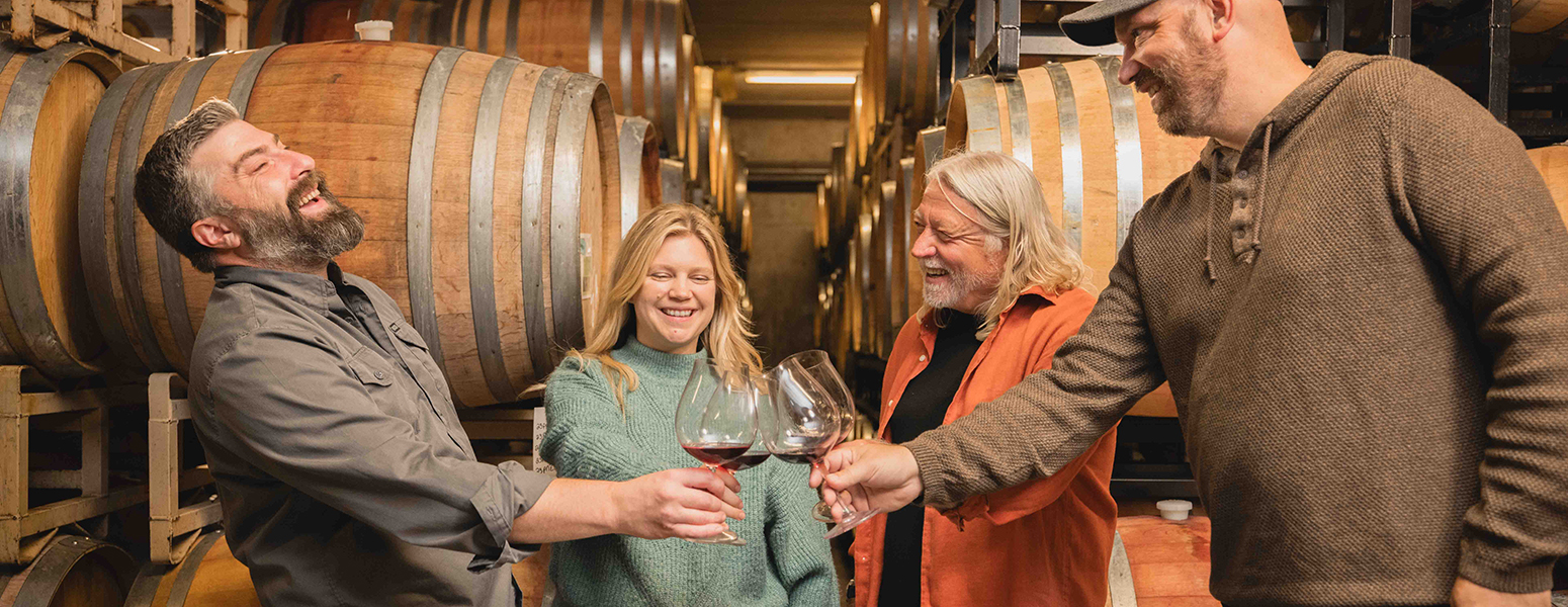 Winemakers having fun and smiling in wine cellar