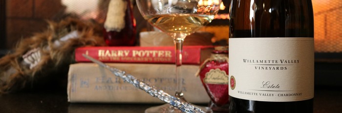 Glass of wine with Harry Potter themed decorations and Harry Potter books.