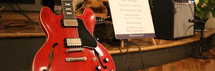 Red electric guitar next to our Tasting Room stage.
