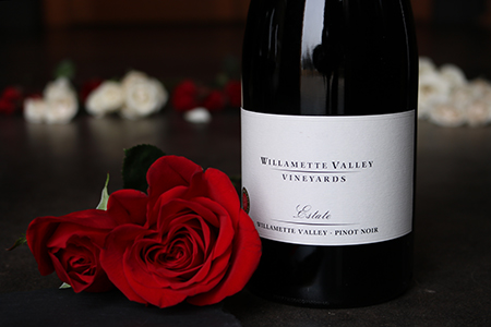 February Pairings Dinner: A bottle of Estate Pinot Noir positioned next to a rose
