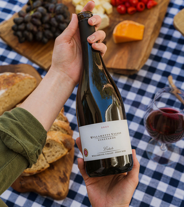 Join or Give the Gift of Wine Club - Images of a bottle of Pinot Noir being held above a picnic table.