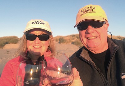 Betty and husband cheersing wine on the beach