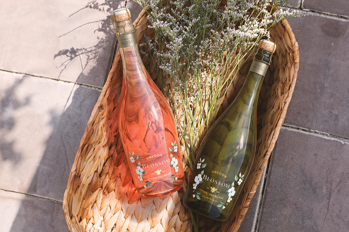 Oregon Blossom Blanc and Rosé sparkling wines in a basket with wildflowers