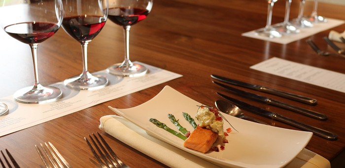 four small plate pairing plates with wines lined up behind them
