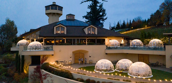 Willamette Valley Vineyards Estate Tasting Room at Dusk with 8 igloos lit up on the patio
